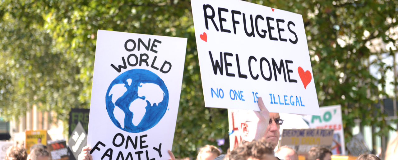 Signs saying 'Refugees welcome' at a protest.