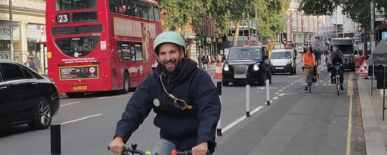 Zack Polanski cycling through Kensington High Street