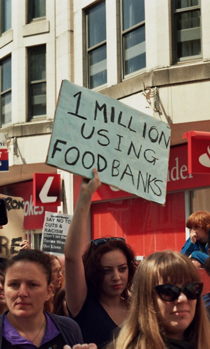 At an anti-austerity protest a placard reads '1 million using food banks'
